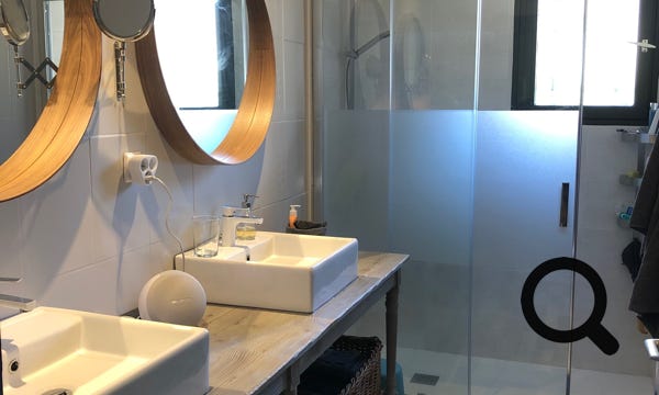 La salle de douche avec double vasques, sèche cheveux